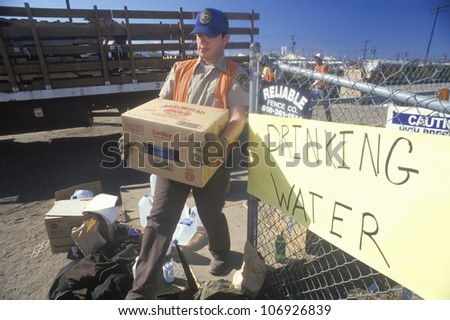 A man carrying drinking water away from a relief station in Santa Clara after the 1994 earthquake