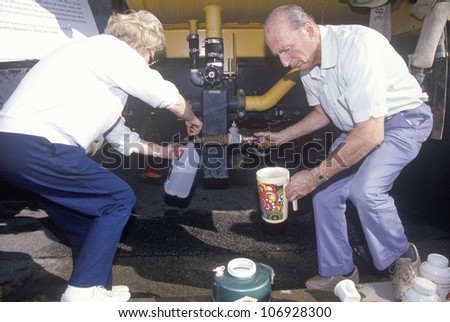 An older couple securing some water from a water line after the Northridge earthquake in 1994
