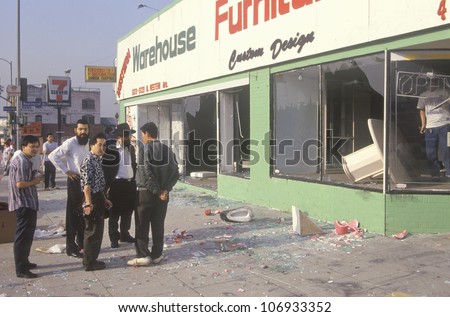 Ethnic men observing furniture store looted during 1992 riots, South Central Los Angeles, California