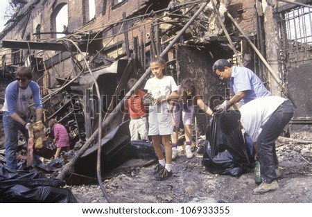 CIRCA 1992 - Family rummaging through home burned during riots, South Central Los Angeles, California