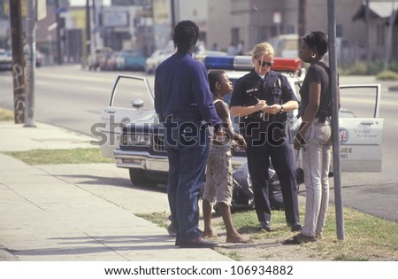 CIRCA 1992 - Policewoman taking a report, South Central Los Angeles, California