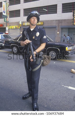 CIRCA 1992 - Police in riot gear holding weapon, downtown Los Angeles, California