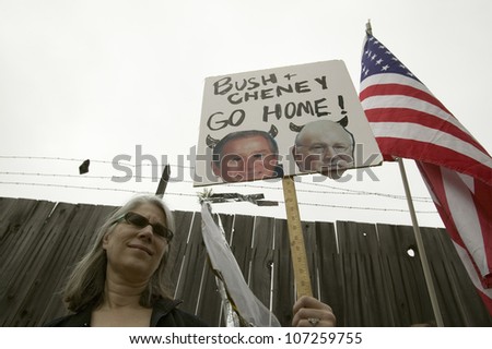 A sign shows President Bush and VP Cheney as the devil with the US Flag at an anti-Iraq War protest march in Santa Barbara, California on March 17, 2007