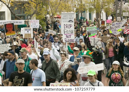A large crowd of protesters march and chant down State Street carrying signs at an anti-Iraq War protest march in Santa Barbara, California on March 17, 2007