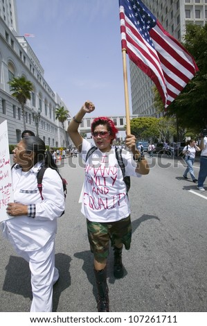 Protestor carries US flag demanding equality with immigrants participating in march for Immigrants and Mexicans protesting Illegal Immigration reform by U.S. Congress, Los Angeles, CA, May 1, 2006