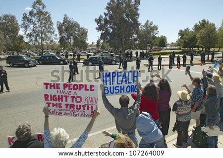 MARCH 2005 - Presidential Motorcade with President George W. Bush past anti-Bush political rally with signs that read Impeach Bush in Tucson, AZ
