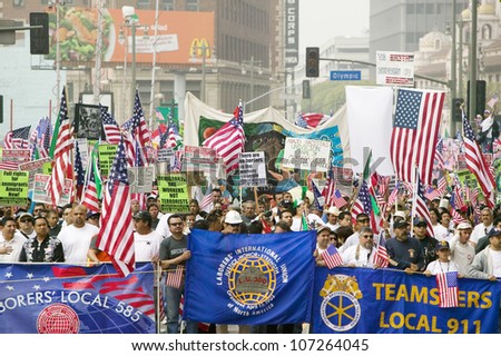 Union worker banners in front of immigrants participating in march for Immigrants and Mexicans protesting against Illegal Immigration reform by U.S. Congress, Los Angeles, CA, May 1, 2006