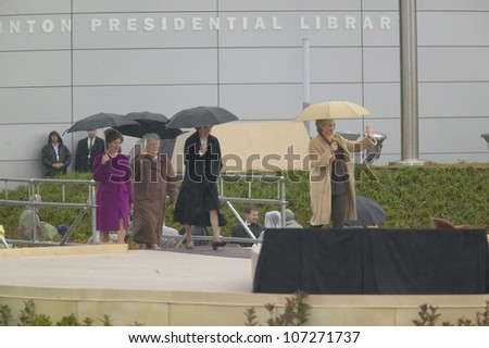 Hillary Clinton walks on stage with Laura Bush, Barbara Bush and Rosalind Carter during the official opening ceremony of the Clinton Presidential Library November 18, 2004 in Little Rock, AK