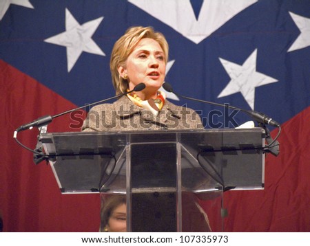 Sen. Hillary Clinton, speaks at a Little Rock, AK luncheon honoring the First Ladies of the state in front of the state flag November 17, 2004 in Little Rock, AK