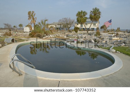 CIRCA 2004 - Swimming pool and American Flag with debris in front of house heavily hit by Hurricane Ivan in Pensacola Florida