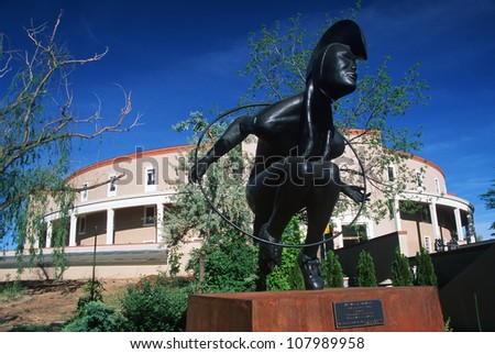 A statue stands in front of the state capital of New Mexico in Santa Fe, New Mexico