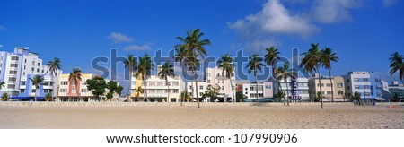 Art Deco District Of South Beach Miami. The Buildings Are Painted In Pastel Colors Surrounded By Tropical Palm Trees.