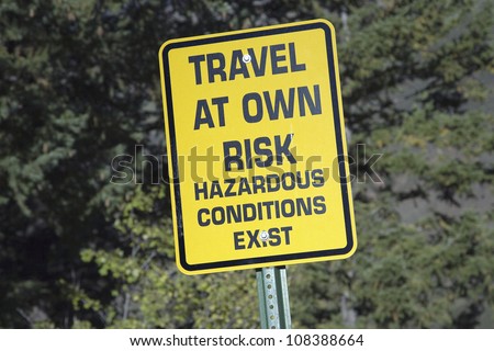 Yellow warning sign reading Travel At your own Risk