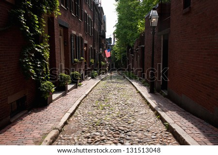 Cobblestone road leads to American Flag on historic Beacon Hill, Boston, MA