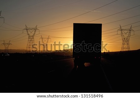 Truck driving into sunset on Interstate 15 in California