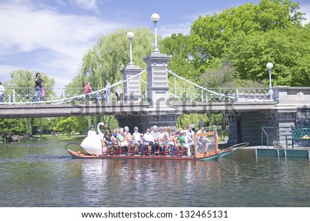 BOSTON - MAY 20: Swan boat with tourists goes by suspension bridge in Public Garden and Boston Common on May 20, 2010, Boston, MA.