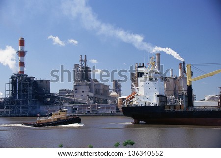 Tugboat following a freighter in the port of Savannah, Georgia