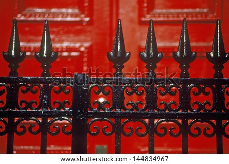Detail of wrought iron gate and red door of boarding school, New York City, NY