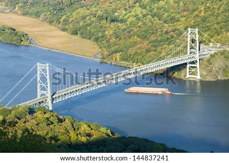 Tugboat with barge under Bear Mountain Bridge and Hudson Valley at Bear Mountain State Park, New York