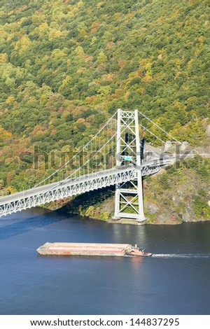 Tugboat with barge under Bear Mountain Bridge and Hudson Valley and River at Bear Mountain State Park, New York