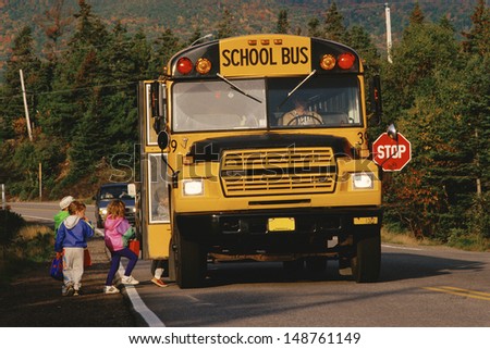 NEW ENGLAND - CIRCA 1980\'s: Children boarding a yellow school bus, New England