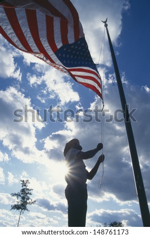 WEST VIRGINIA - CIRCA 1980\'s: Man raising the American flag in New Gorge National Park, West Virginia