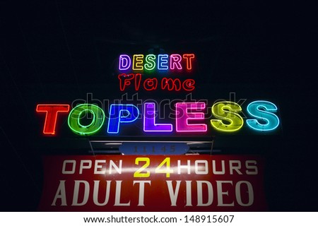 PHOENIX, AZ - CIRCA 1980's: Neon sign advertising a strip club and Adult Video store near Phoenix AZ