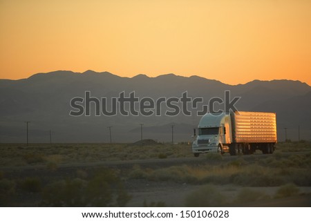 MOJAVE DESERT, CA - JULY 29: 18-wheeler semi-trucks hit the highway at sunset driving down Interstate Highway 15 between Los Angeles and Las Vegas Nevada on July 29, 2004 in Southern California