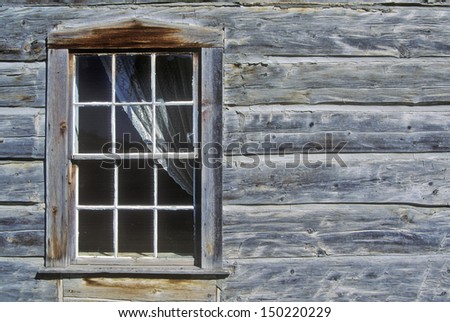 VIRGINIA CITY MONTANA - CIRCA 2000\'s: Window with curtain in log building in Ghost Town near Virginia City, MT