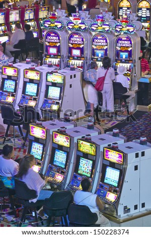 LAS VEGAS, NEVADA - CIRCA 2004: Rows of slot machines and gamblers at Rio Casino in Las Vegas, NV