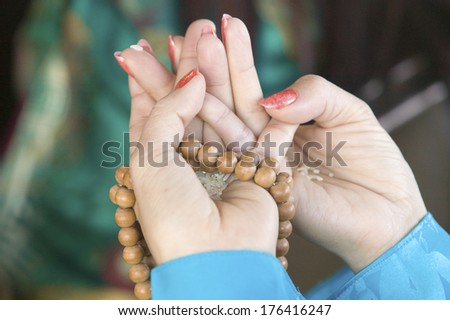 A woman\'s hands hold prayer beads and rice at an Amitabha Empowerment Buddhist Ceremony, Meditation Mount in Ojai, CA