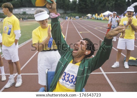 Volunteer cheering with handicapped athlete, Special Olympics, UCLA, CA