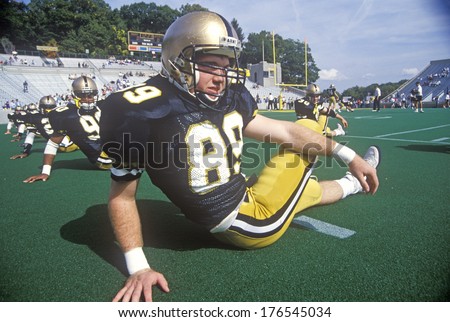 College football player doing pre-game stretch at the  Army vs. Lafayette game, Michie Stadium, New York