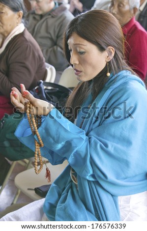 A woman\'s hands hold prayer beads and rice at an Amitabha Empowerment Buddhist Ceremony, Meditation Mount in Ojai, CA