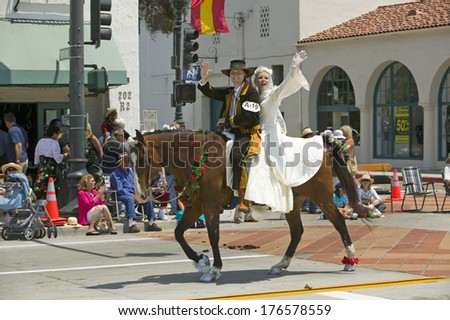Bride and groom in Spanish outfits riding horse together during opening day parade down State Street, Santa Barbara, CA, Old Spanish Days Fiesta, August 3-7, 2005