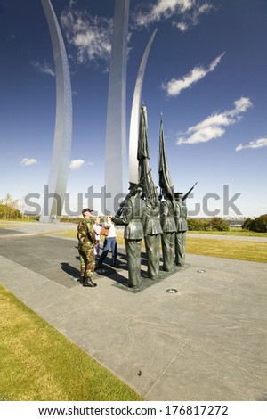 Military family look at Bronze Honor Guard and three soaring spires of the Air Force Memorial, Arlington, Virginia in Washington D.C. area