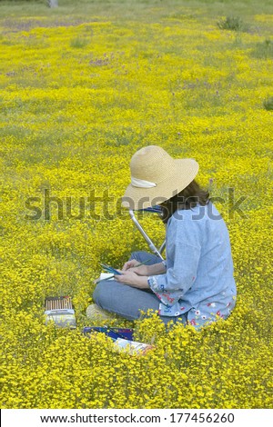 An artist using her colored pencils to sketch the colorful spring flower fields off of Highway 58, central CA