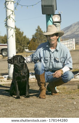 Cowboy with his dog kneel down at the Sands Motel at the intersection of Route 54 & 380 in Carrizozo, New Mexico