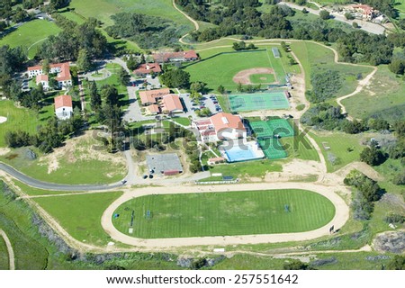 Springtime aerial view of Villanova Prep school with track, pool, baseball diamond, tennis courts and campus in view, Ojai, CA