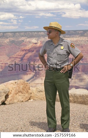 Female National Park ranger looking at South Rim of Grand Canyon National Park in mid-summer in Arizona
