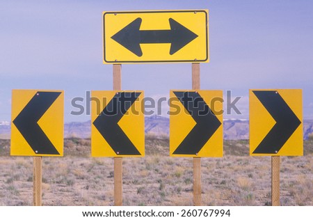 Miscellaneous yellow and black arrows in the desert pointing in various directions