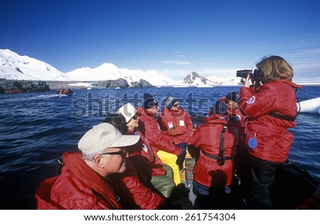 Ecological tourists from cruise ship Marco Polo in inflatable Zodiac boat at Paradise Harbor, Antarctica