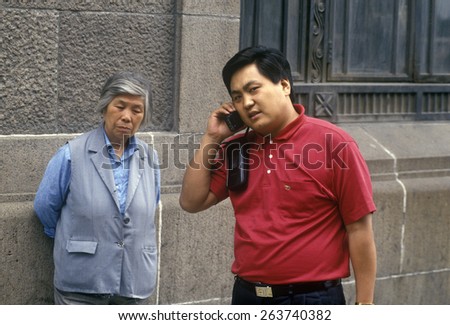 Chinese businessman on cellular phone in Shanghai, Zhehiang Province, People's Republic of China
