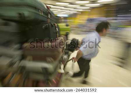 Baggage man pulls luggage at Madrid Barajas Airport (MAD), Spain\'s busiest airport