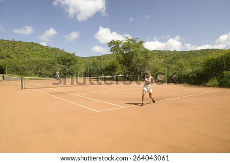 A tourist couple enjoy a game of outdoor tennis at Lewa Downs in North Kenya, Africa.