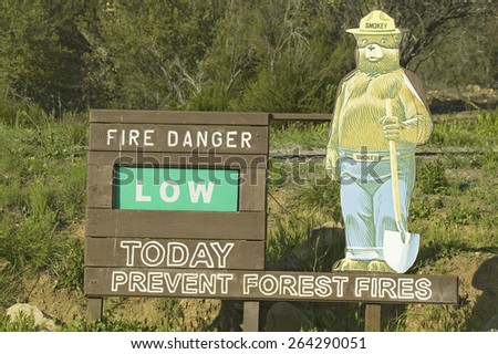 Smokey the Bear\'s US Forestry sign reading that there is a Low Risk of a forest fire today, Las Padres National Forest, Ventura County, California.