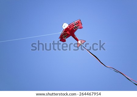 An airplane shaped red kite flying in a deep blue sky on April 15, 2007, at the Santa Barbara Kite Festival, Santa Barbara City College, overlooking Pacific Ocean.
