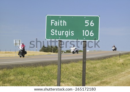 State Highway 34 with highway sign for Sturgis South Dakota and motorcyclist\'s heading away from the 67th Annual Sturgis Motorcycle Rally, Sturgis, South Dakota, August 6-12, 2007