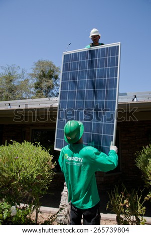 Two male solar workers install solar panels on home in Oak View, Southern California