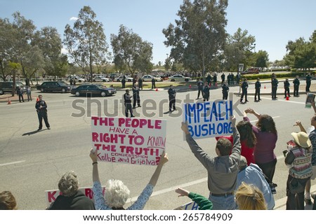 Presidential Motorcade with President George W. Bush past anti-Bush political rally with signs that read Impeach Bush in Tucson, AZ